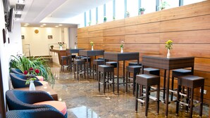 A hotel lobby with wicker chairs, a reception desk, and potted plants. - Hotel Beyfin (Cluj-Napoca)