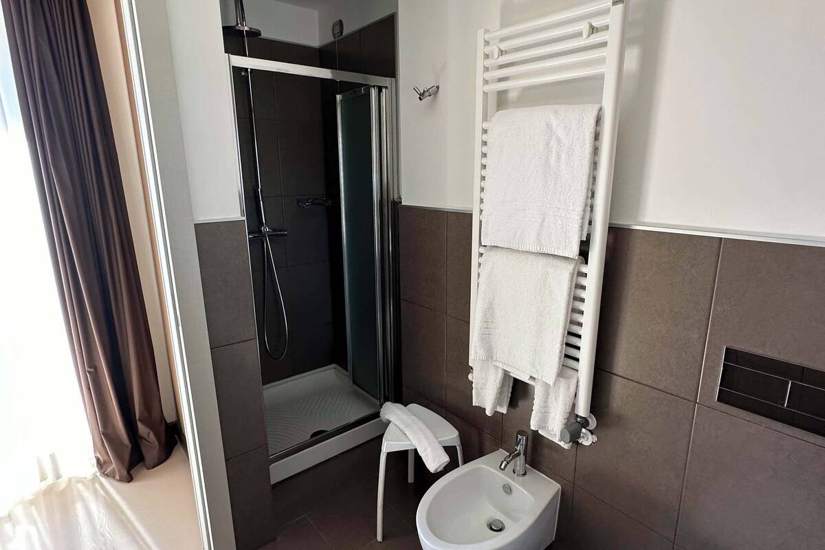 shower, hair dryer, slippers, towels