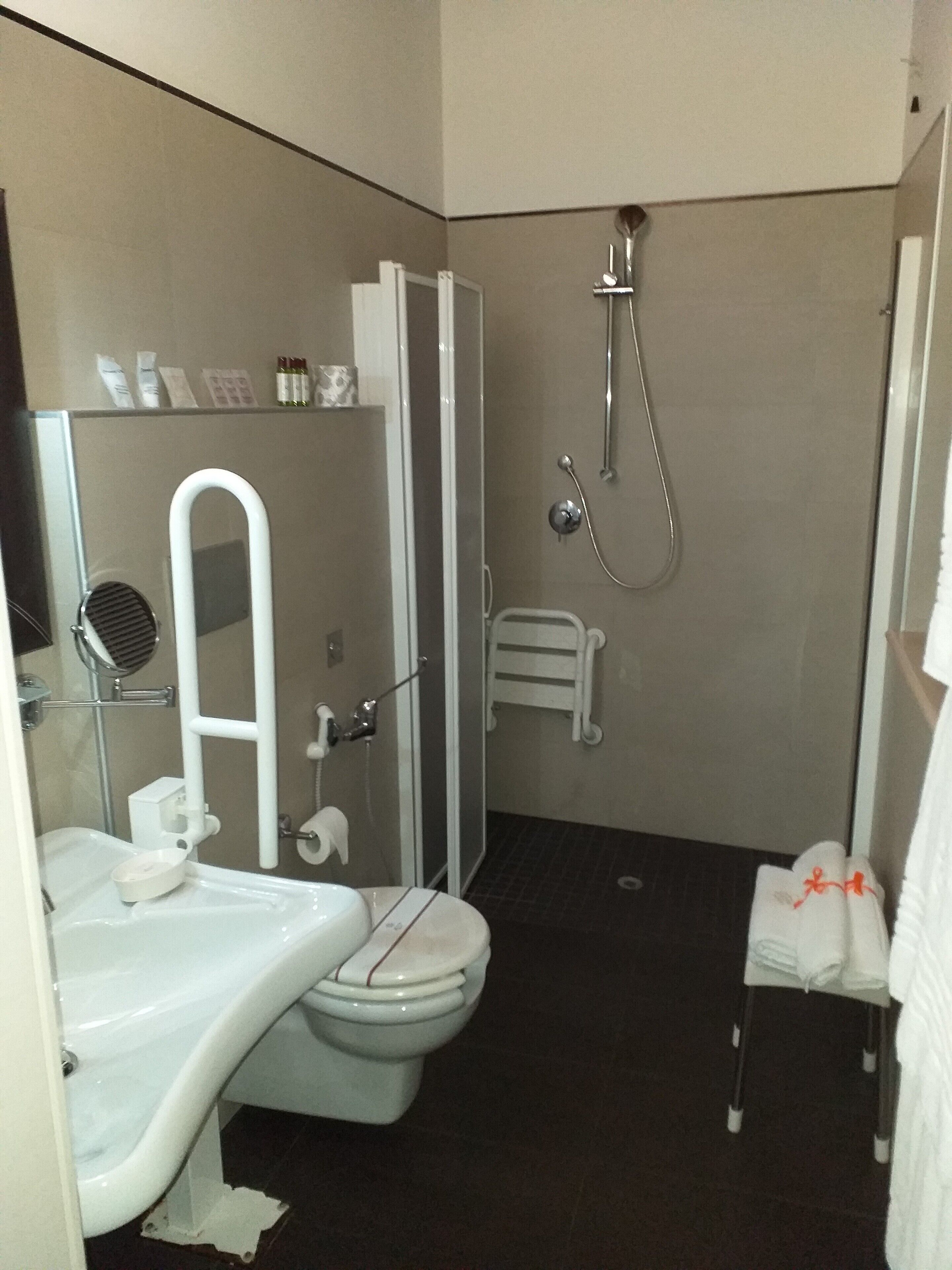Un baño pequeño con inodoro, lavamanos y ducha.