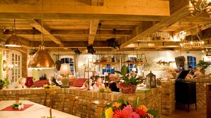 Un intérieur rustique avec des poutres apparentes, un comptoir en pierre et des luminaires suspendus.