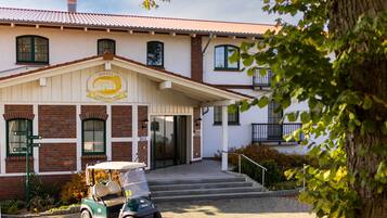 A hotel with a sign reading "Hotel Strelasund," a brick facade, and a golf cart parked in front.