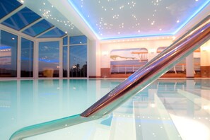 Una piscina cubierta, tumbonas