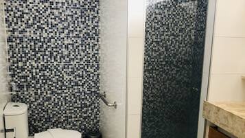 A bathroom with a shower, toilet, and sink.