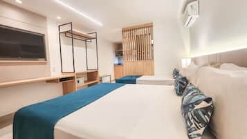 Une chambre d’hôtel moderne équipée d’un grand lit, d’un bureau, d’une télévision et d’une kitchenette.