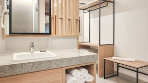 A modern bathroom with a granite countertop sink, wooden vanity, and a mirror above the sink. - Blu Smart Stay (Búzios)