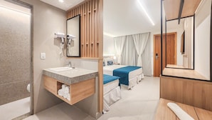 A hotel room with a wooden vanity, a bed with blue bedding, a large mirror, and a wooden door. - Blu Smart Stay (Búzios)