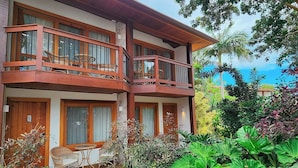 A two-story building with balconies, outdoor seating, and lush greenery. - Blu Smart Stay (Búzios)