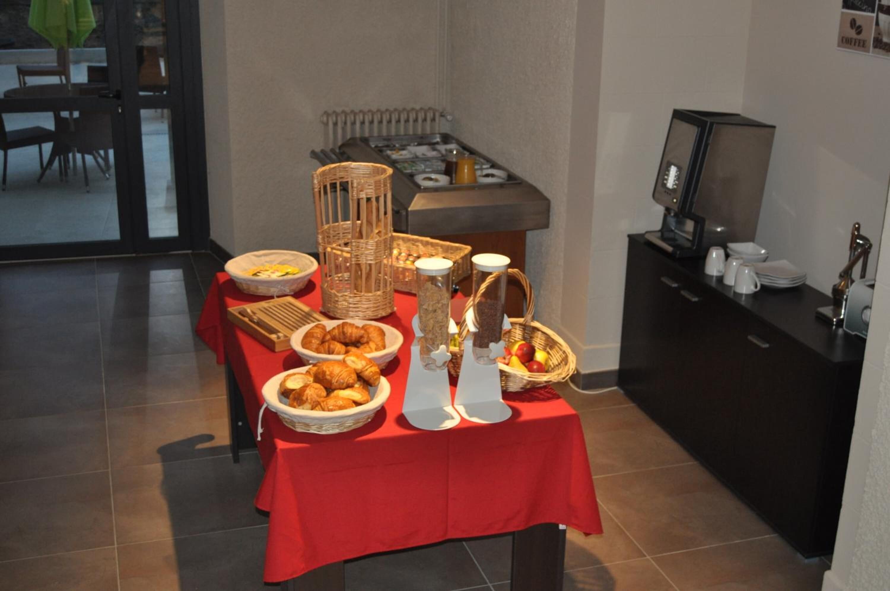 A breakfast buffet table with various food items and a coffee machine.