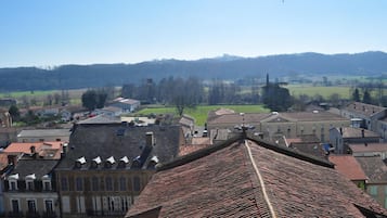 A town with traditional architecture, including buildings with red-tiled roofs and a central green square.