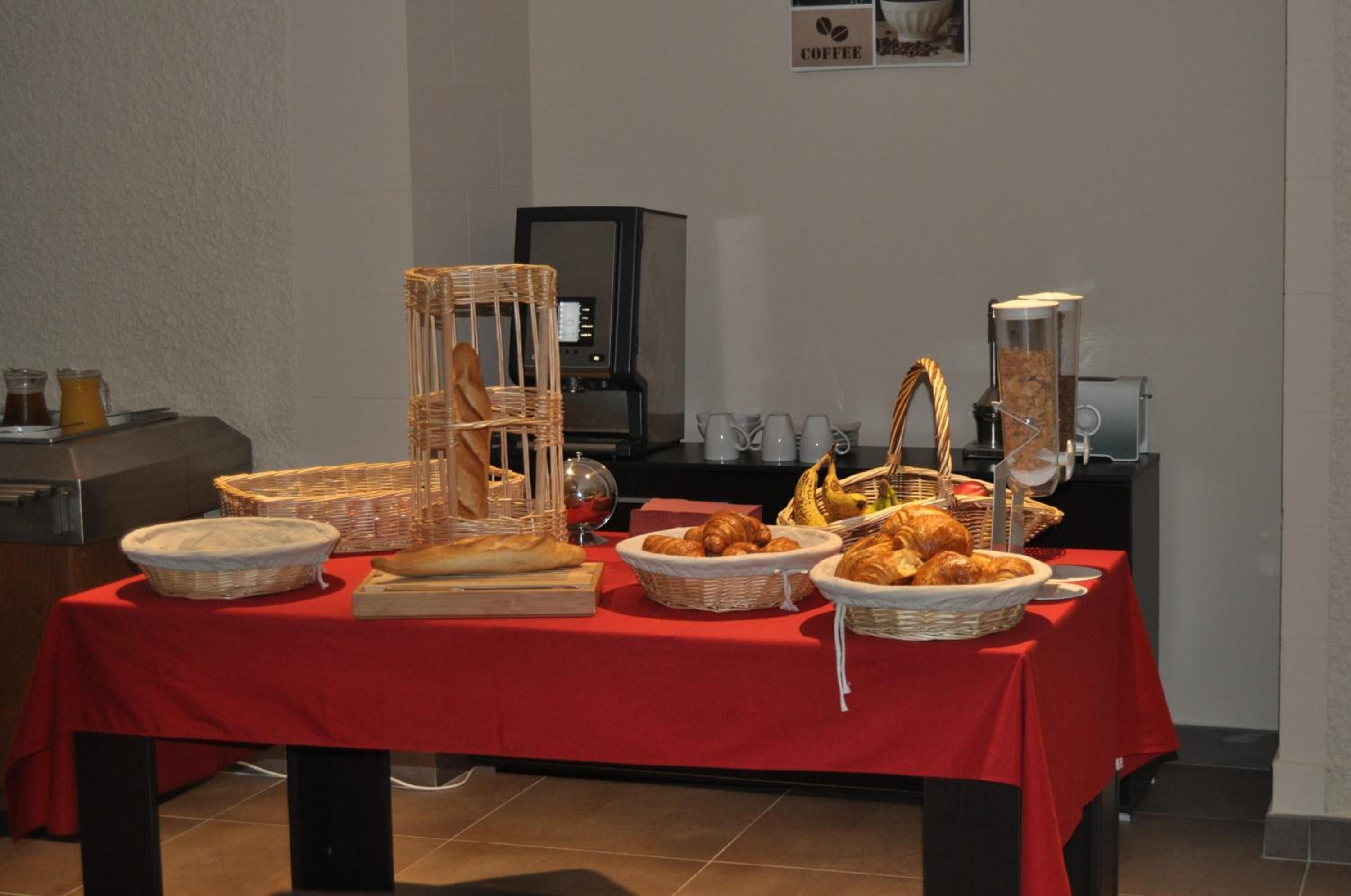Un buffet pour le petit-déjeuner avec du pain, des viennoiseries et du matériel pour préparer le café.