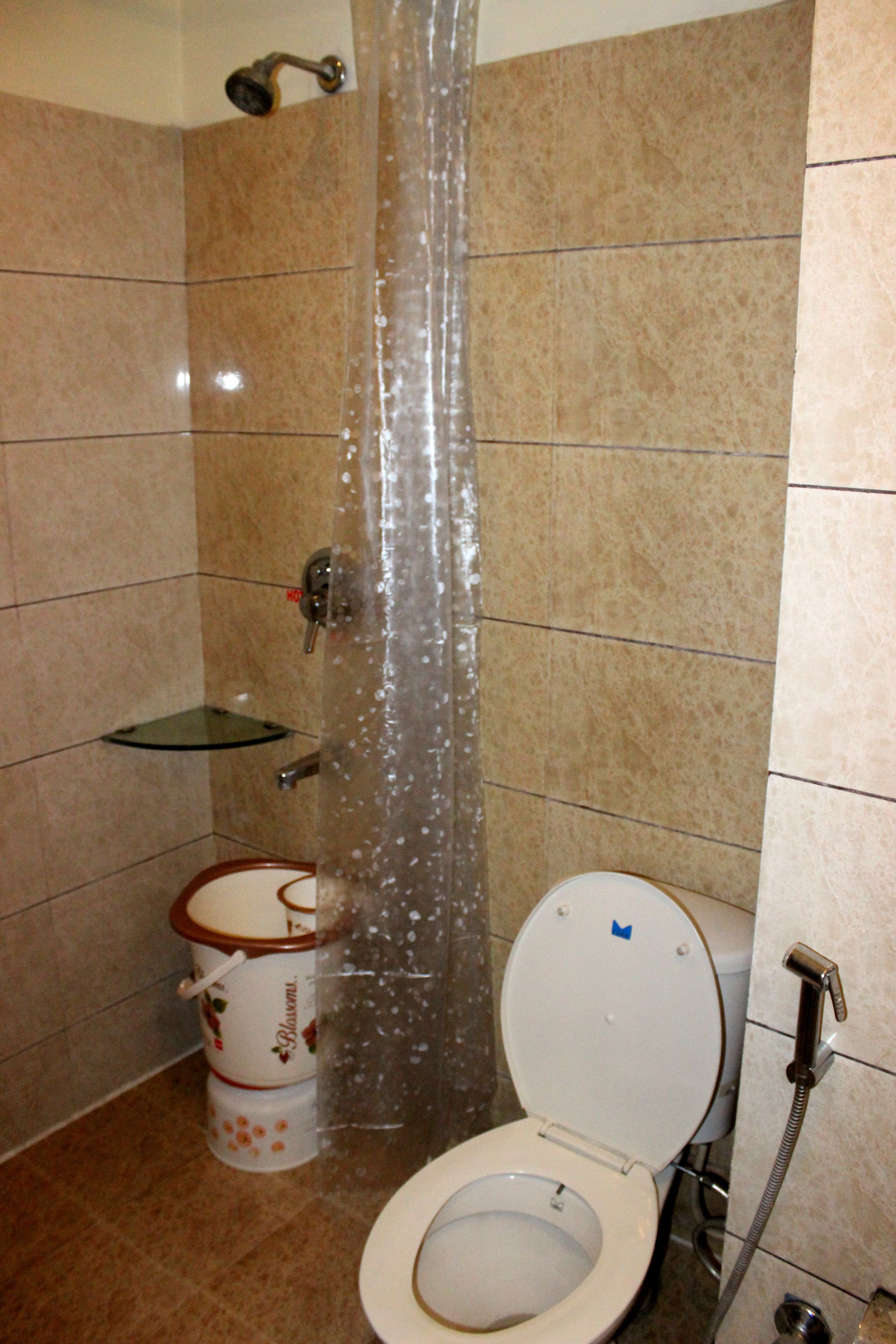 A bathroom with a shower, toilet, and a glass soap dish.