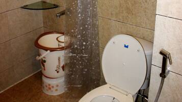 Un baño con ducha, inodoro y un jabonera de vidrio.