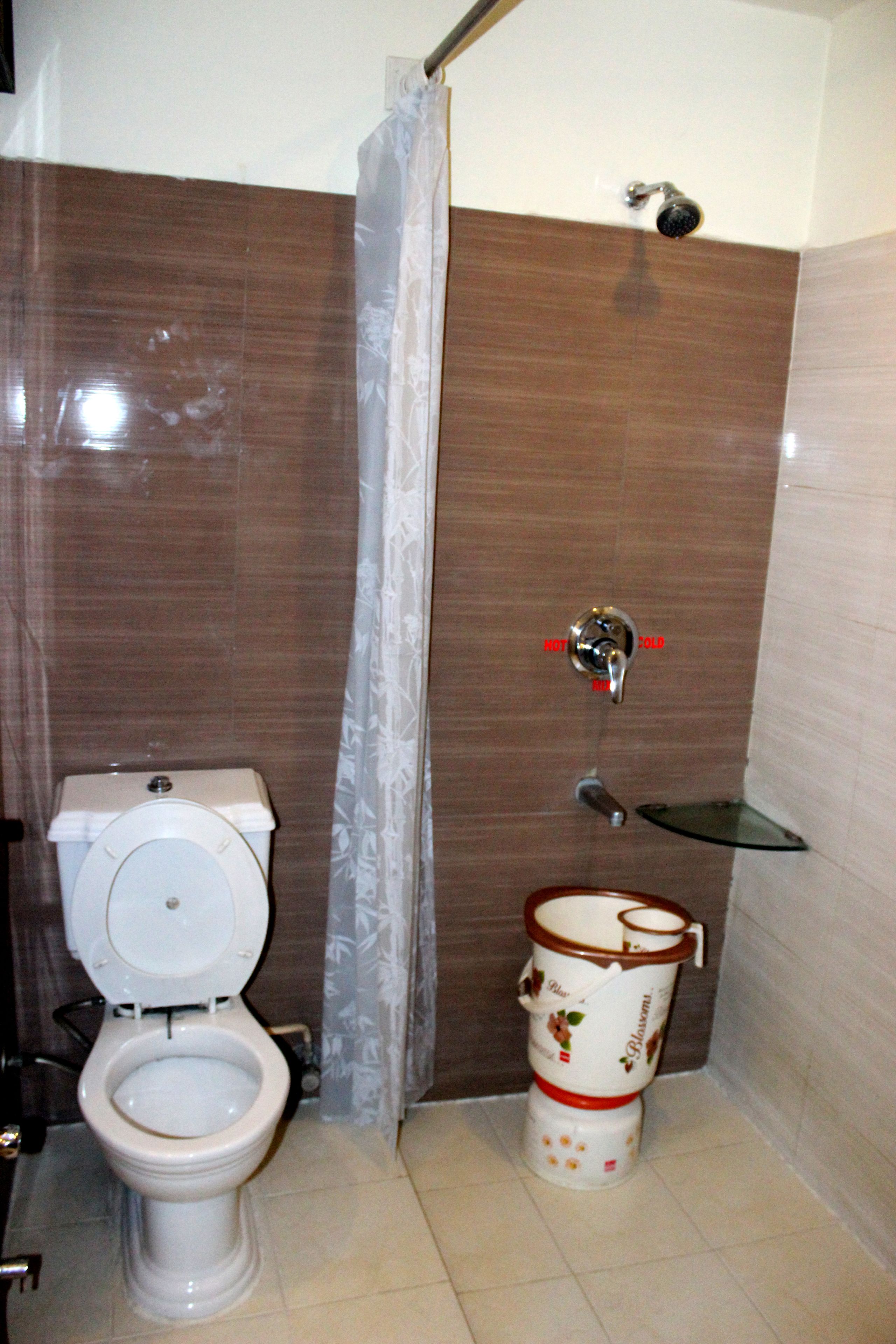 A bathroom with a toilet, a shower, and a bidet.