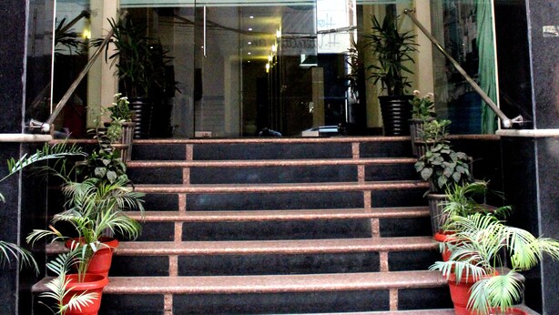The entrance to the Hong Kong Inn hotel with a staircase leading up to the entrance, flanked by potted plants. - Hotel Hong Kong Inn (Amritsar)