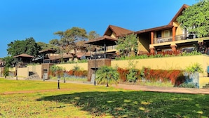 A hotel with multiple buildings, a well-maintained lawn, and a clear sky. - Regenta MPG Club (Mahabaleshwar)