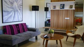 A modern living room with a grey sofa, a wooden coffee table, and a chair.