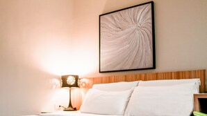 A neatly made bed with white linens in a hotel room. - Zpad Residences (Tacloban)