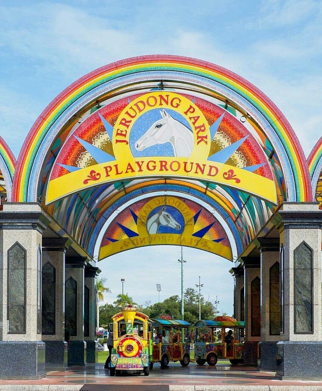 Un arco colorido con el texto "Jerudong Park Playground" y la silueta de un caballo.