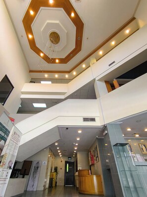 A multi-level interior with a central staircase, recessed lighting, and a hexagonal ceiling design. - Jubilee Hotel (Bandar Seri Begawan)
