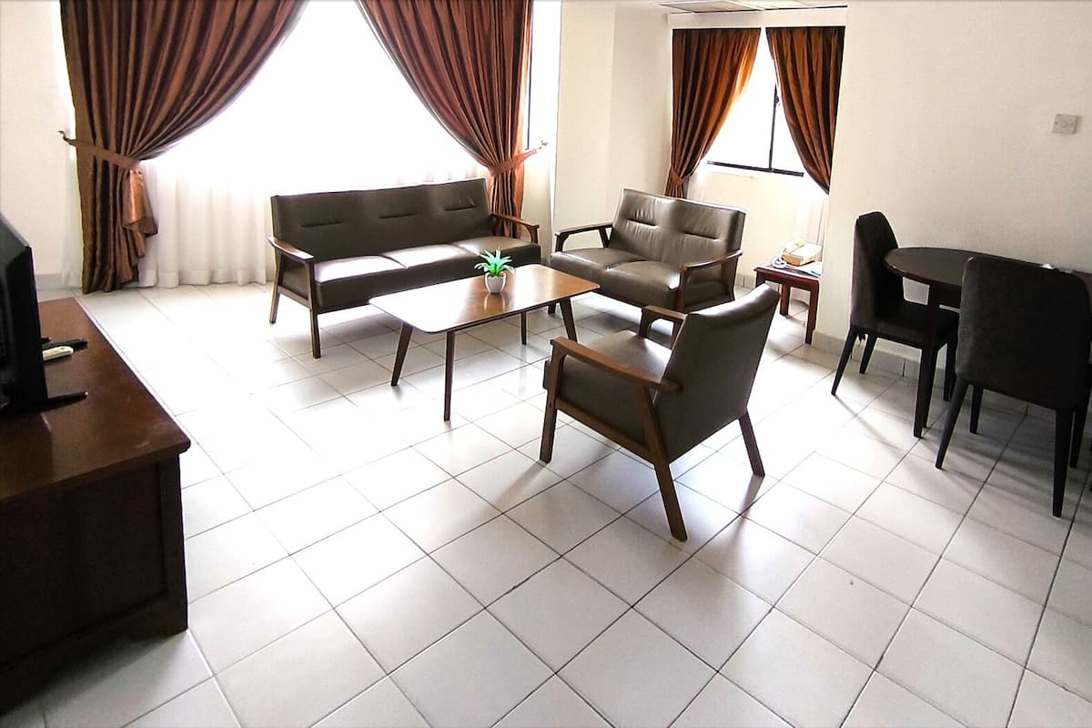 A living room with a sofa, chairs, a coffee table, and a dining table.
