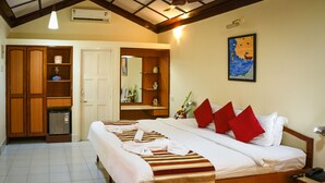 A hotel room with a large bed, a wardrobe, a small fridge, and a painting on the wall. - Baia Do Sol - Beach Boutique (Baga)