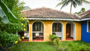A yellow building with a tiled roof, arched windows, and a small porch area. - Baia Do Sol - Beach Boutique (Baga)