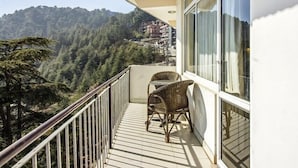 A balcony with a view of a forested hillside. - Villa Paradiso (Dharamshala)