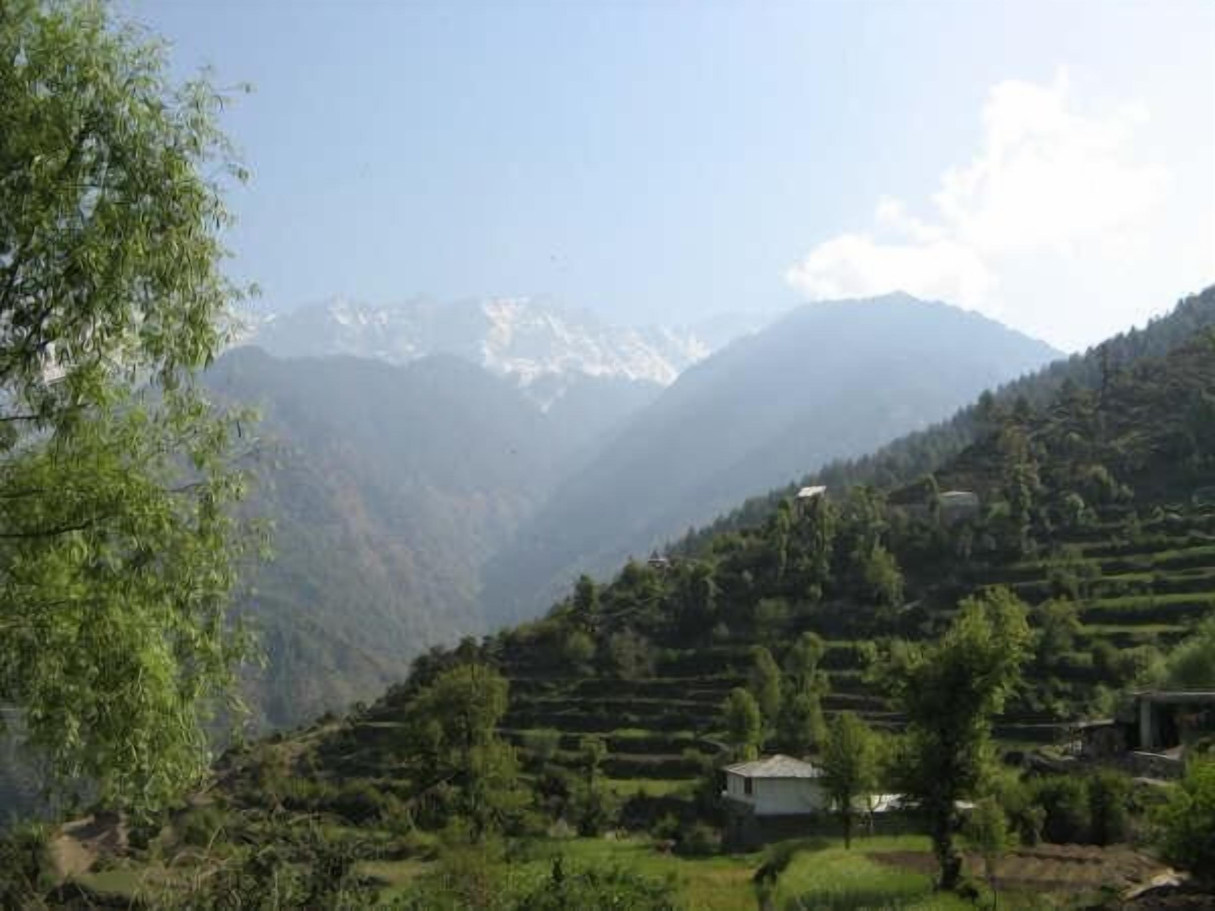 A mountainous landscape with terraced fields and a small building.