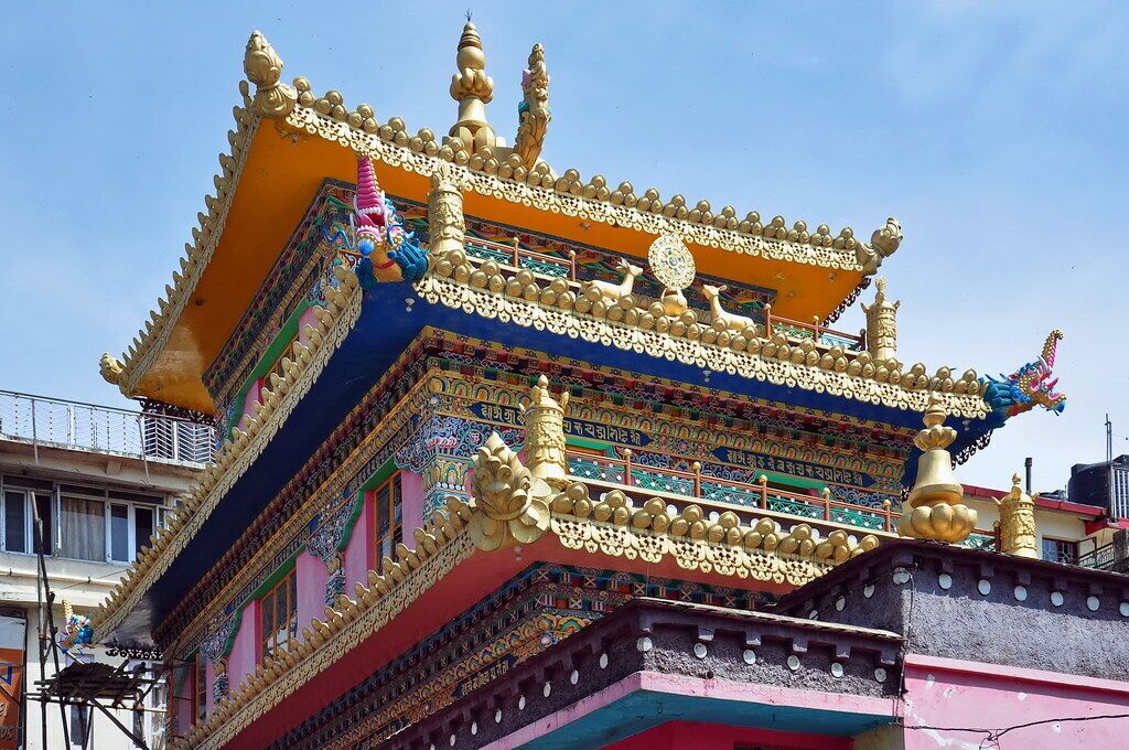 A multi-tiered building with ornate golden decorations and colorful patterns.