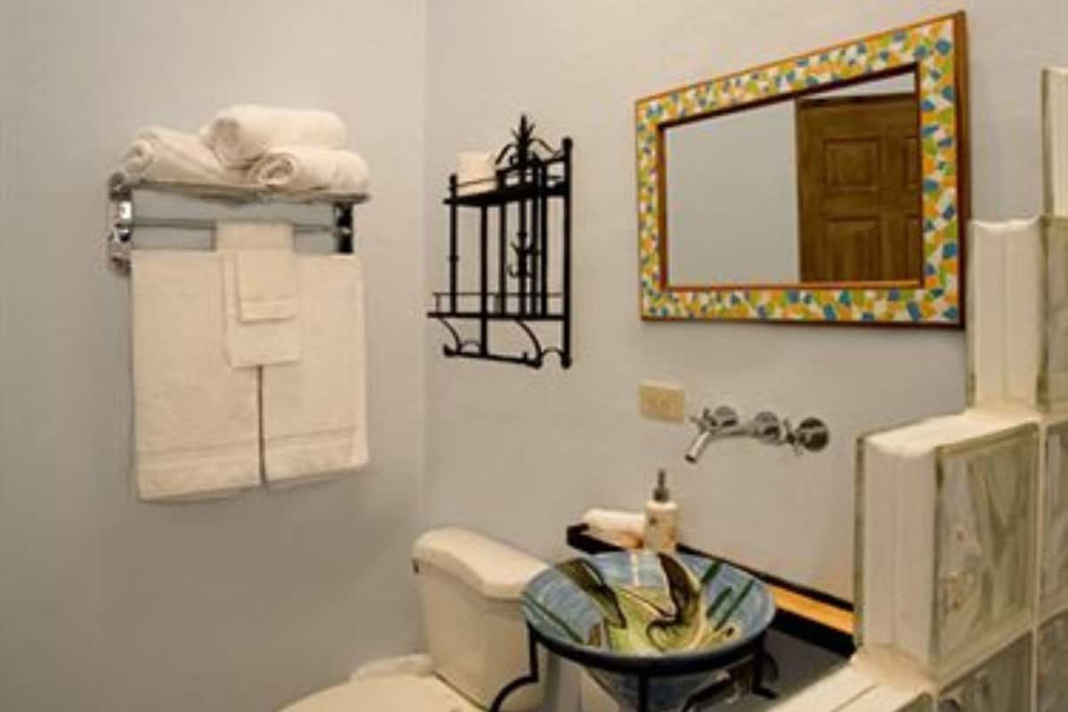 A bathroom with a toilet, sink, and towel rack.