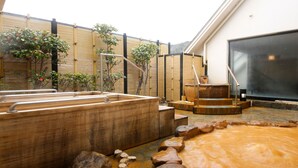 A traditional Japanese onsen with wooden tubs, a stone hot spring, and a bamboo fence. - Arima Hot spring Ryokan Hanamusubi (Kobe)