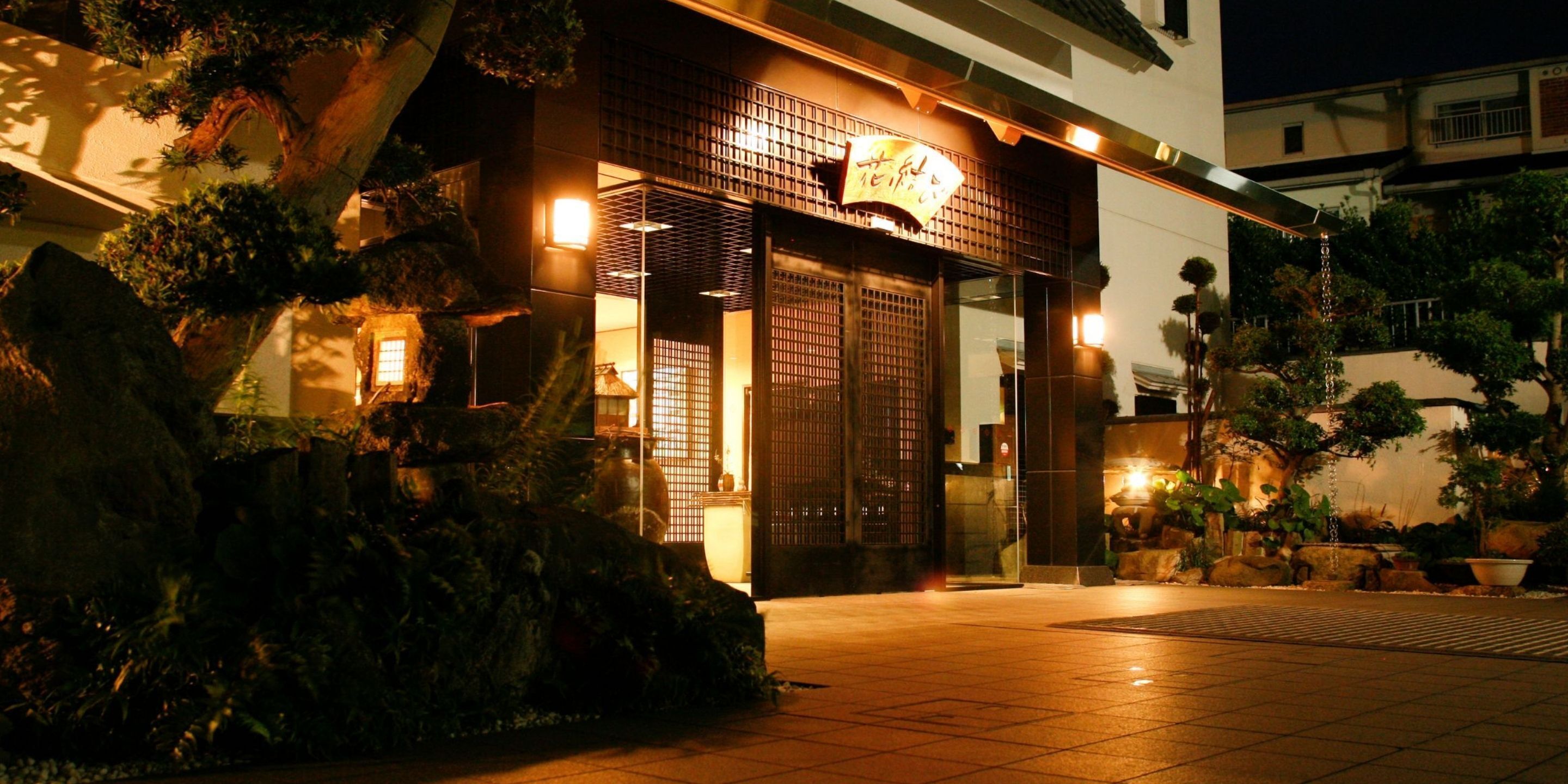 A traditional Japanese building with a tiled entrance, wooden doors, and a sign above the entrance.