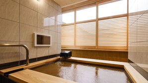 A modern spa area with a wooden bath, tiled walls, and a window with blinds. - Arima Hot spring Ryokan Hanamusubi (Kobe)