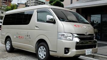 A beige van parked on a street with a license plate and some text on the side.
