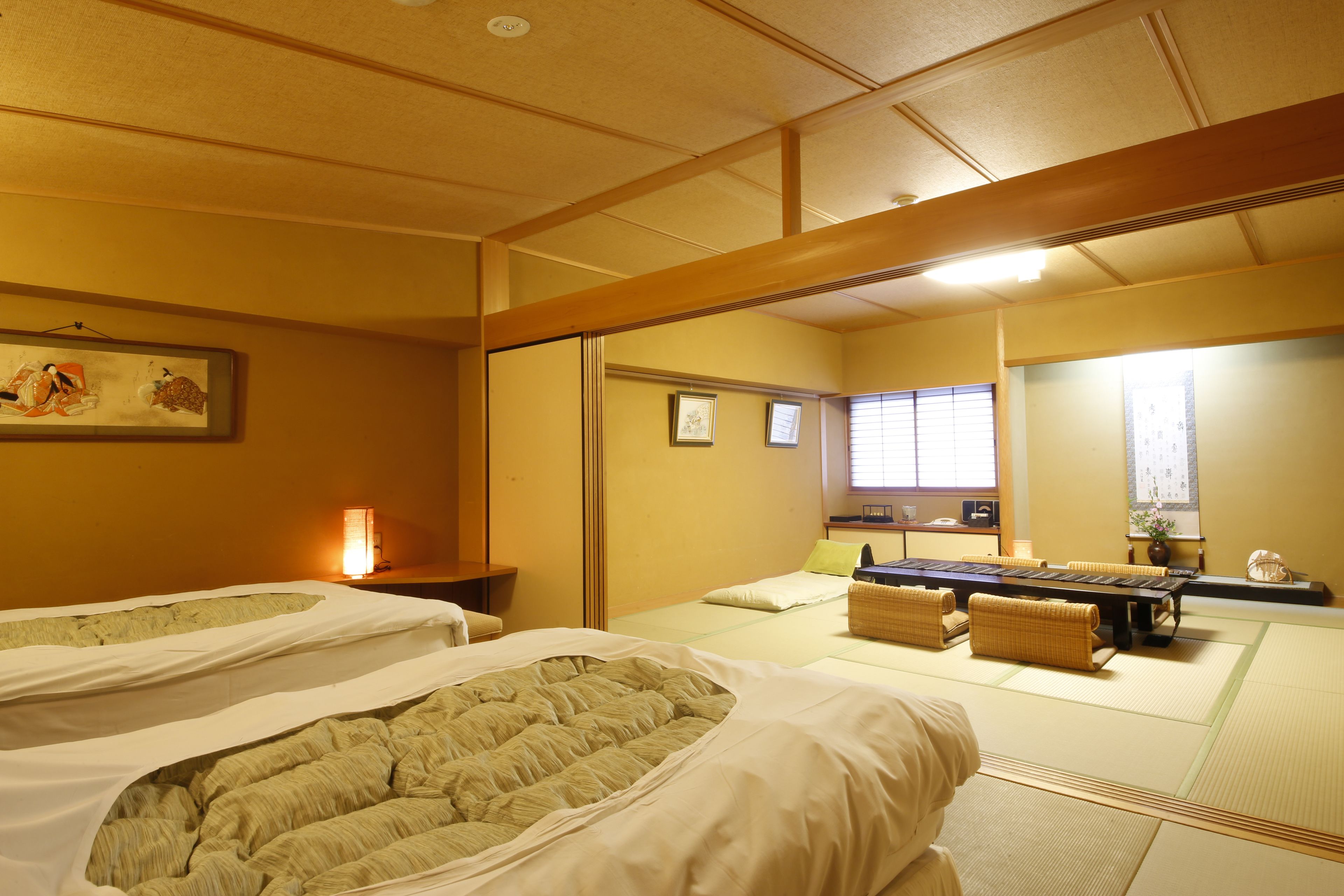 A traditional Japanese room with tatami flooring, two tatami mats, a low table, and a sliding door.