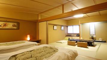 A traditional Japanese room with tatami flooring, two tatami mats, a low table, and a sliding door.