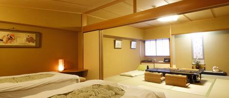 A traditional Japanese room with tatami flooring, two tatami mats, a low table, and a sliding door.