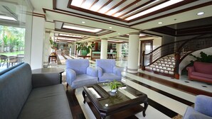 A spacious lobby with a grand staircase, comfortable seating, and a reception area. - Hotel Centro Puerto Princesa, Palawan (Puerto Princesa)