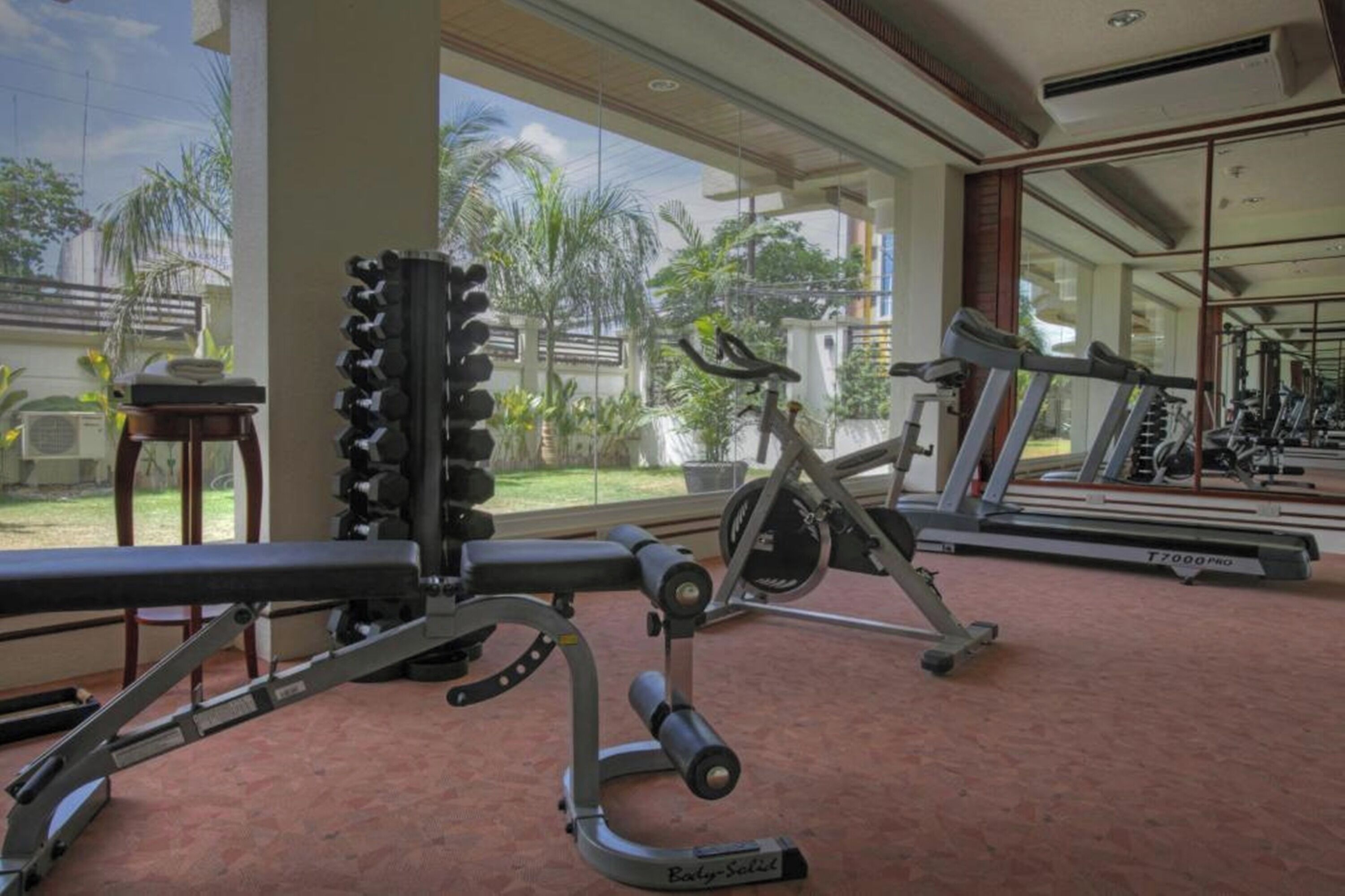 A gym with cardio equipment, weight machines, and a treadmill.