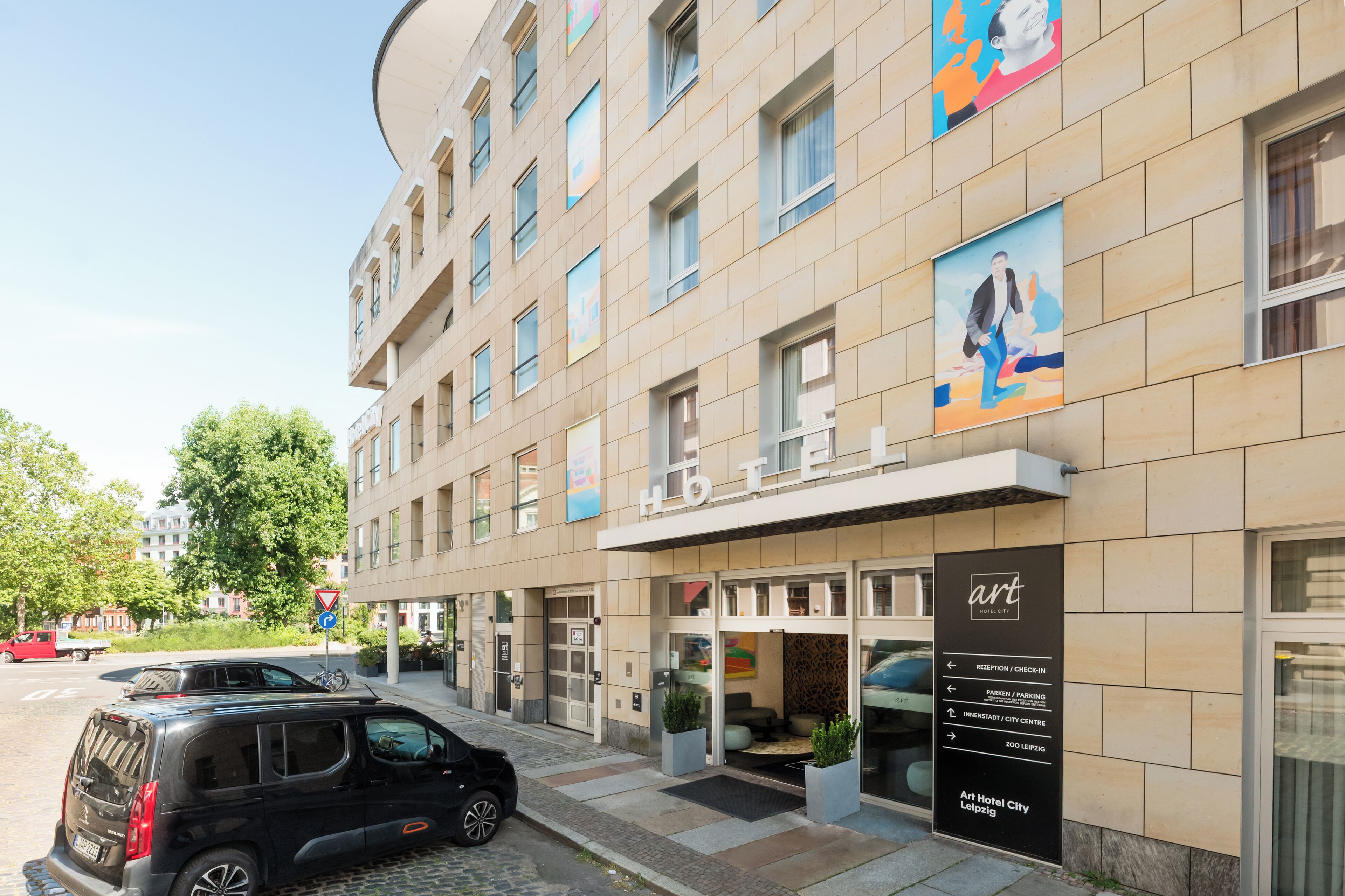 A hotel with a modern facade, a reception area, and directional signage.