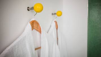Une salle de bain avec des serviettes blanches suspendues à un porte-serviettes.