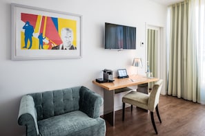 Relax in a stylish space with a sofa, desk, and flat-screen TV.