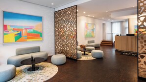 A modern lobby with a reception desk, seating areas, and artwork on the walls. - Art Hotel City Leipzig (Leipzig)