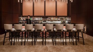 A bar area with multiple seating arrangements and a bartender.
