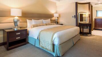 A hotel room with a large bed, two bedside tables with lamps, a dresser, and a mirror.