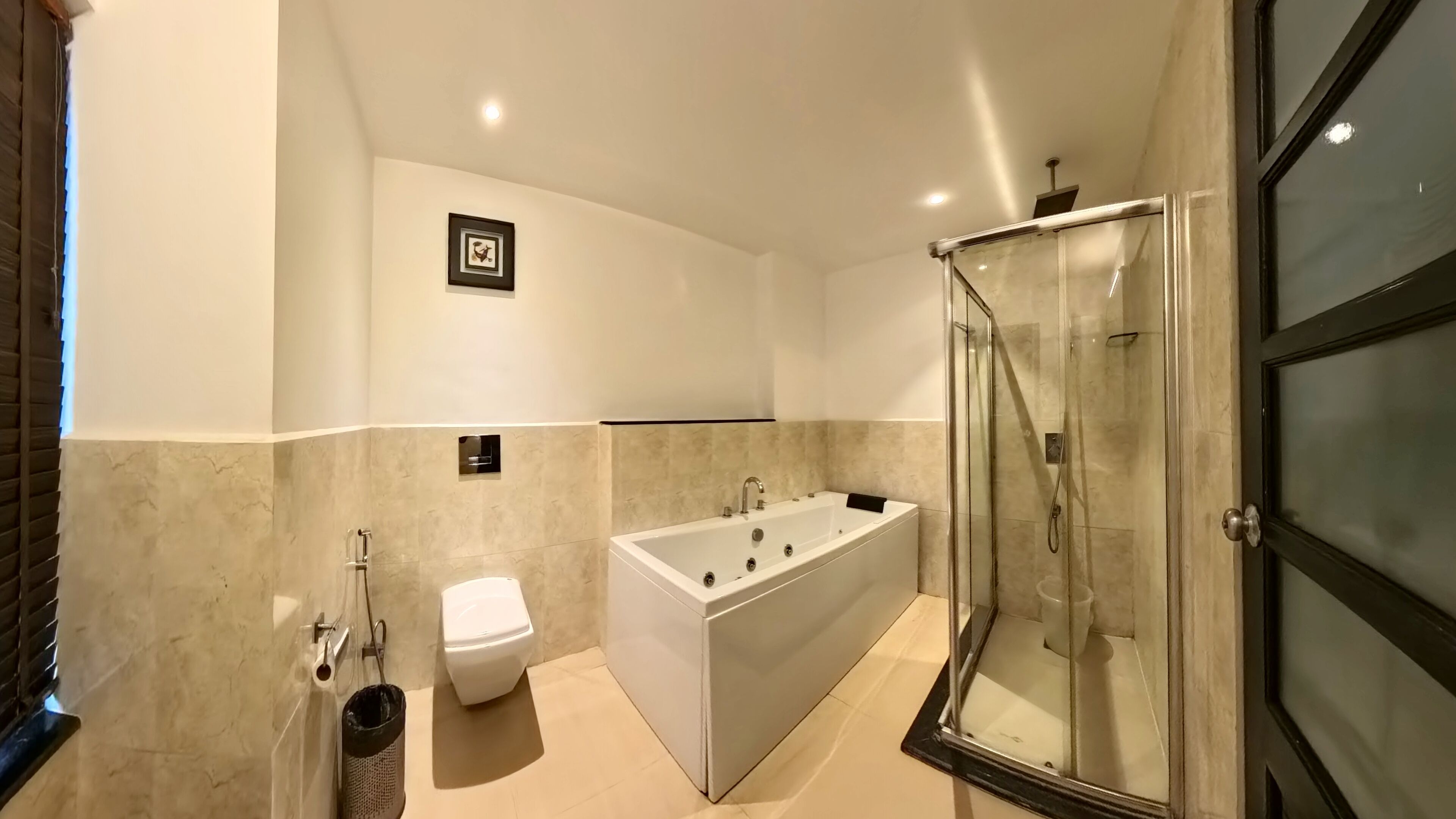 Un baño moderno con bañera, inodoro y ducha envuelta en vidrio.