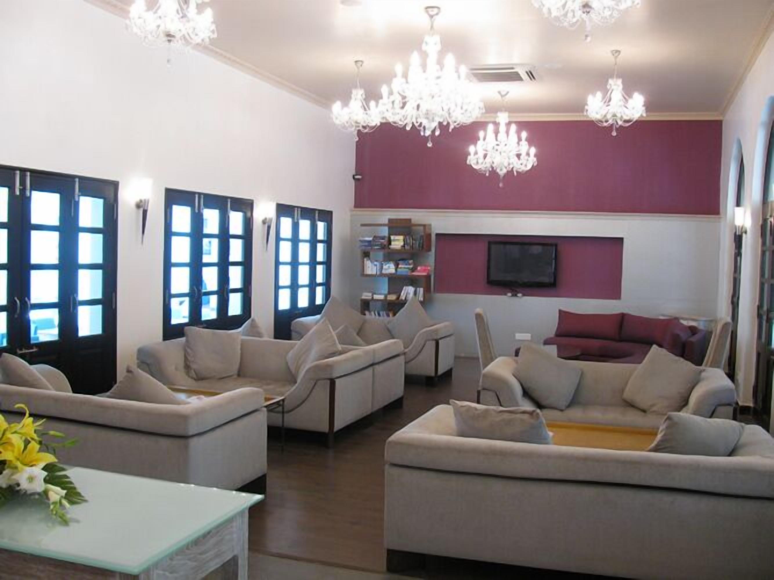 A modern living room with a fireplace, comfortable seating, and a flat-screen TV.
