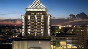 A high-rise hotel with a distinctive pyramid-shaped top, multiple floors, and a modern facade. - Classic Kameo Hotel & Serviced Apartments, Rayong (Rayong)