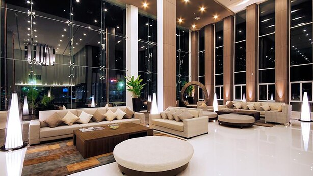 A spacious lobby with large windows, modern furniture, and decorative lighting. - Classic Kameo Hotel & Serviced Apartments, Rayong (Rayong)