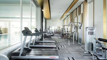 A gym with treadmills, weight machines, and a water fountain.